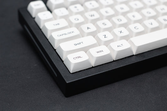 a close up of a white keyboard on a black surface