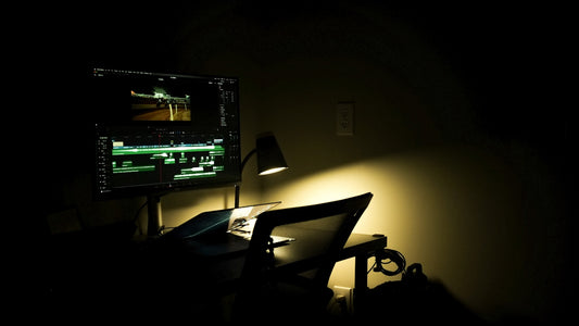 a dark room with a desk and a computer monitor