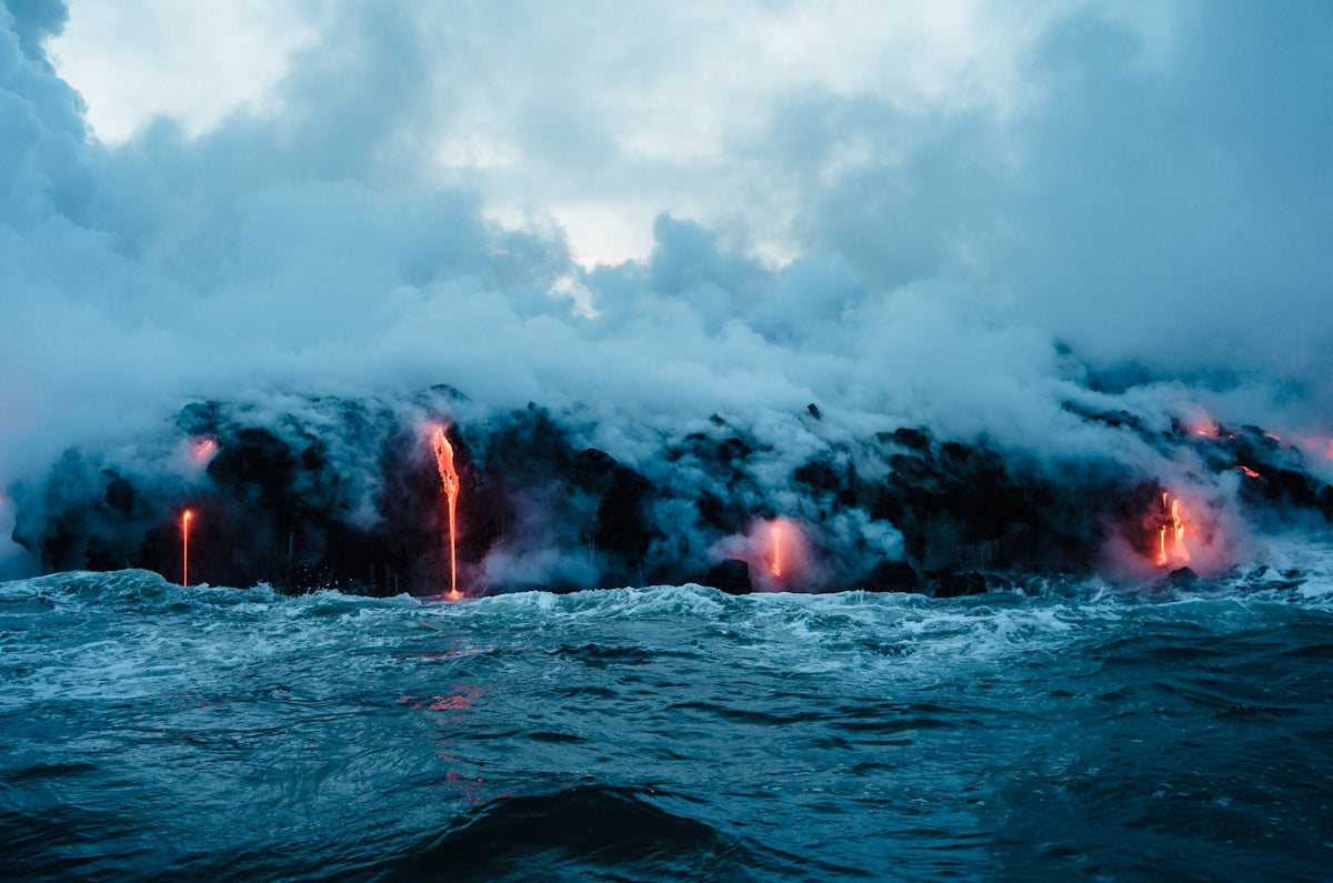 Molten lava flowing into the ocean at Kalapana, creating thick clouds of steam