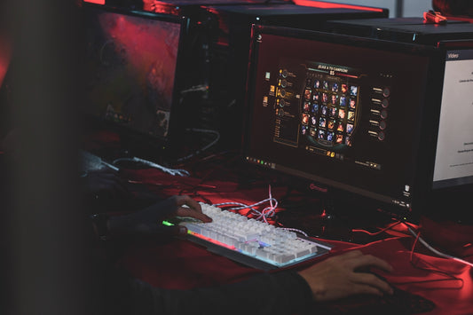 a person sitting at a desk with a keyboard and monitor