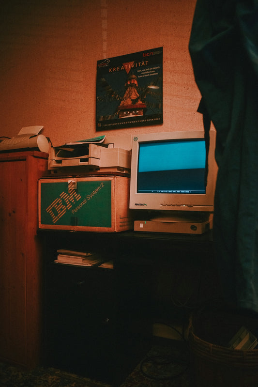 silver crt computer monitor on brown wooden desk