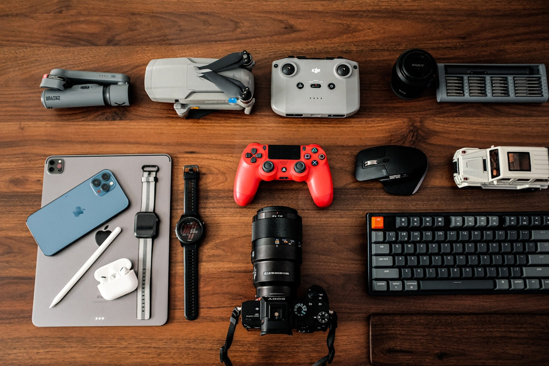 a wooden table topped with electronics and a keyboard