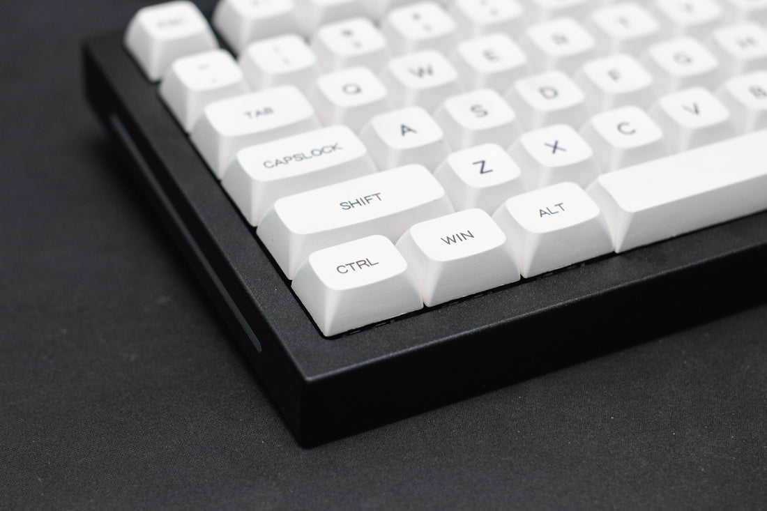a close up of a white keyboard on a black surface