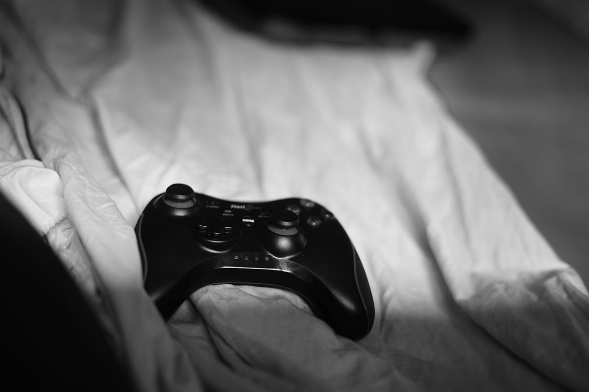 a close up of a controller on a bed