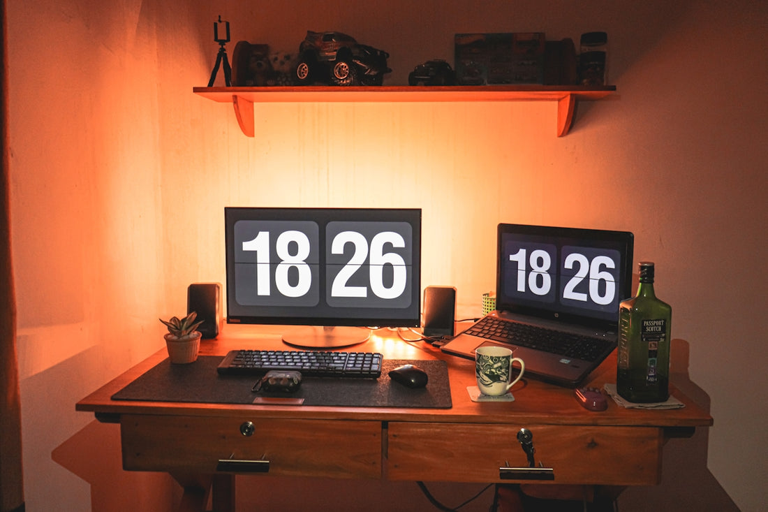 a desk with a computer and a clock on it