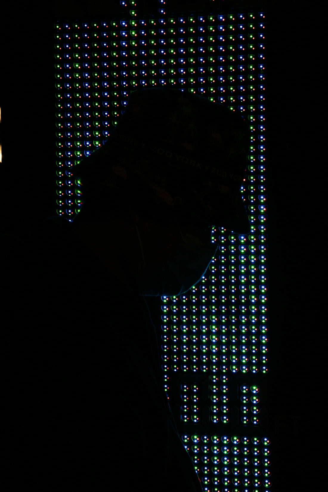 a person's face in a dark room with a large window