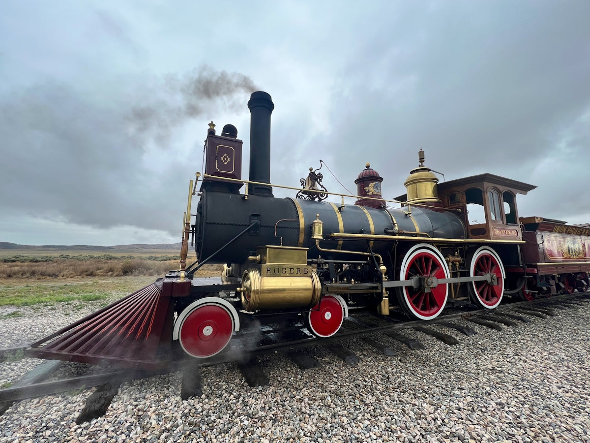 an old fashioned steam engine on a gravel road