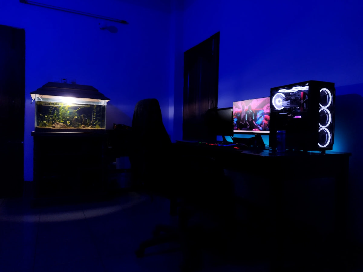 a person sitting in front of a monitor in a dark room
