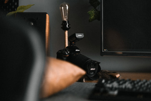 a desk with a monitor, keyboard and a camera