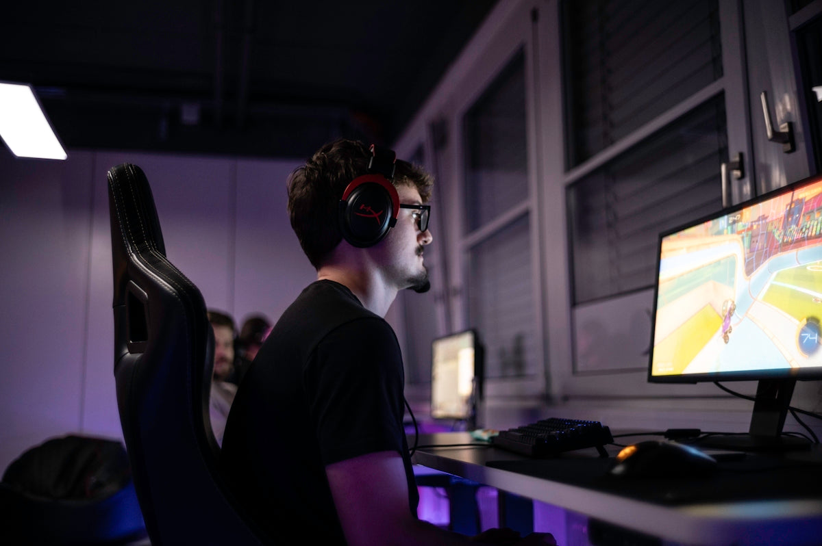 a man sitting in front of a computer with headphones on