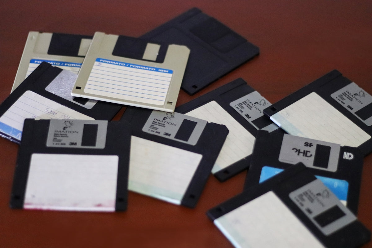 A pile of floppy disk drives sitting on top of a table