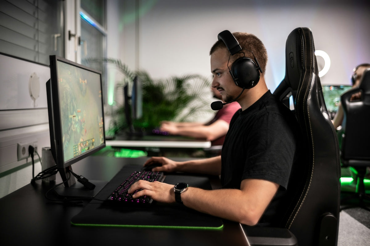 A man sitting in front of a computer with headphones on