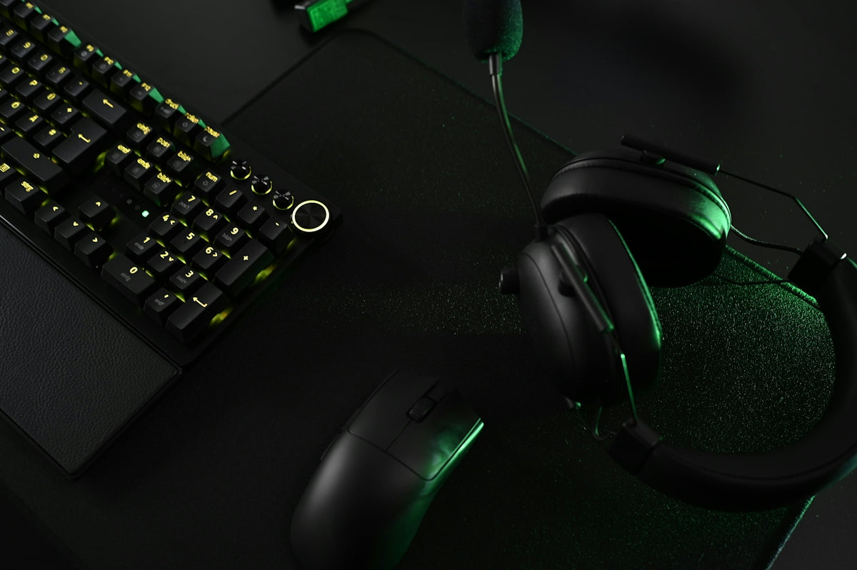 A close up of a keyboard and headphones on a desk