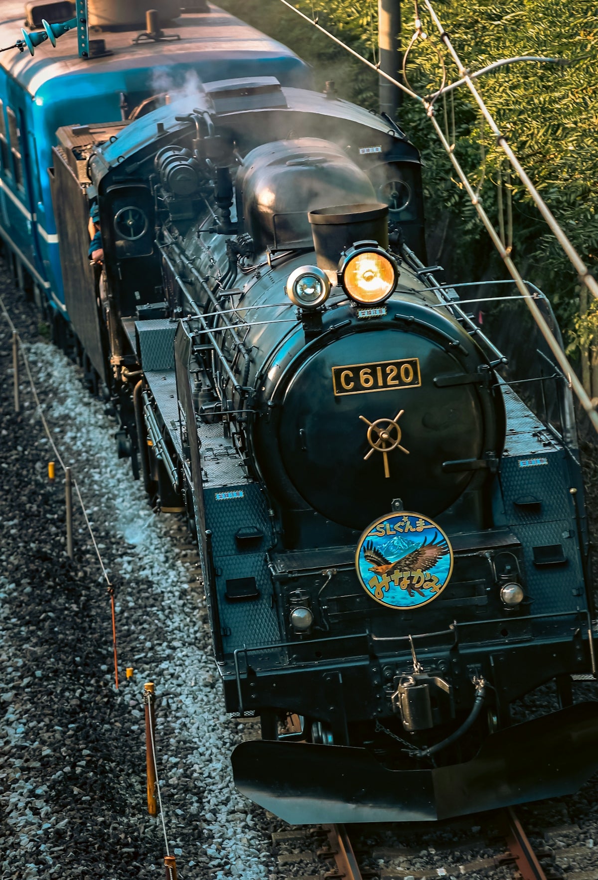 A train traveling down train tracks next to a forest