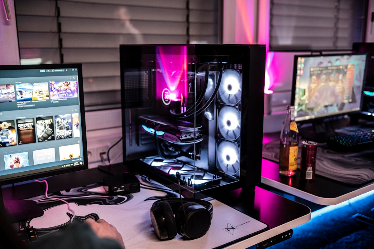 A man sitting at a desk with three computer monitors