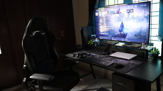 A computer desk with a large monitor and keyboard