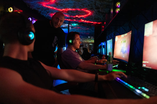 People playing video games in a dimly lit room.