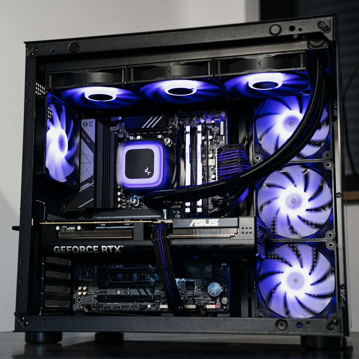 A computer case interior with glowing purple fans and a liquid cooling system