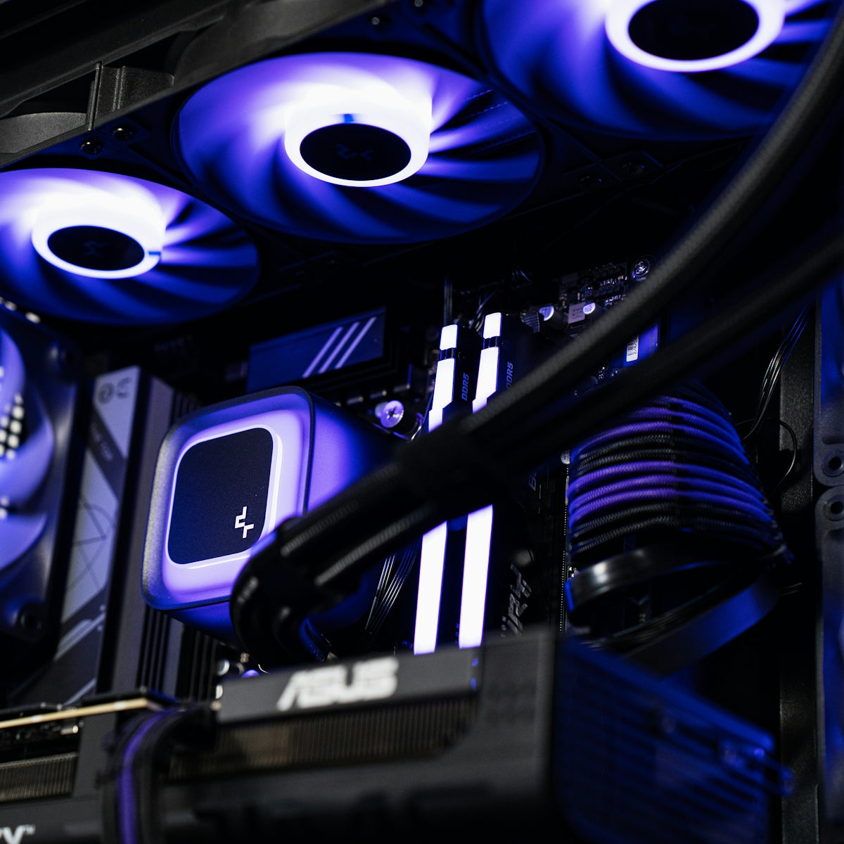Internal view of a computer case with glowing purple fans and liquid cooling