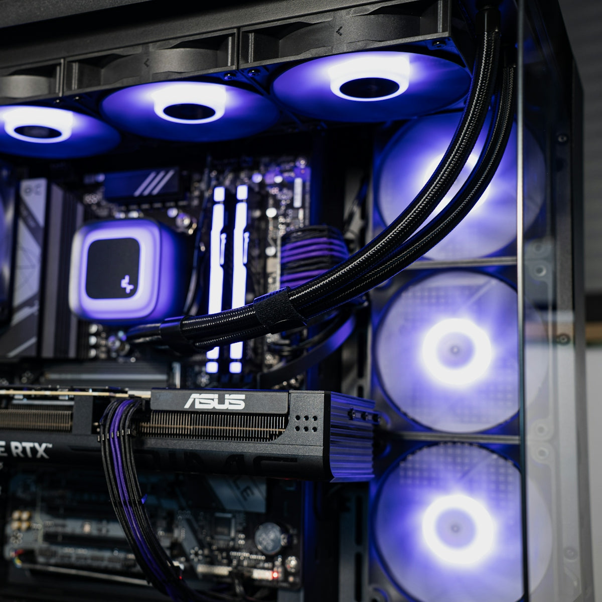 A computer interior with glowing purple fans and an ASUS graphics card